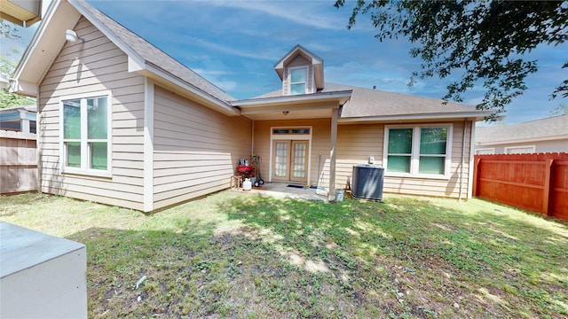 exterior space with central AC, a front yard, french doors, and a fenced backyard