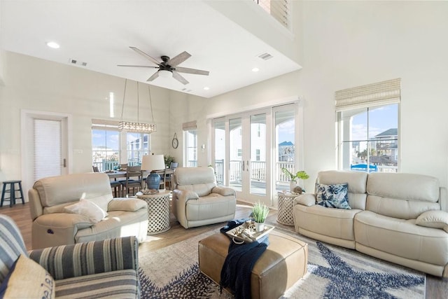 4110 Defender Ln, Galveston, TX 77554 - living room featuring a healthy amount of sunlight, visible vents, a ceiling fan, and a high ceiling