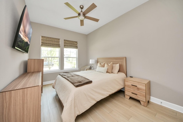 bedroom with baseboards, ceiling fan, and light wood-type flooring