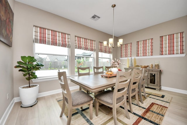 dining area featuring a notable chandelier, visible vents, plenty of natural light, and light wood-type flooring