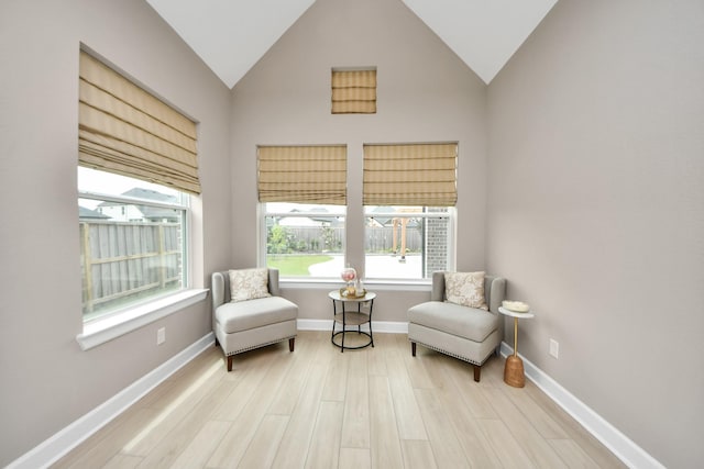 sitting room featuring baseboards, wood finished floors, and vaulted ceiling