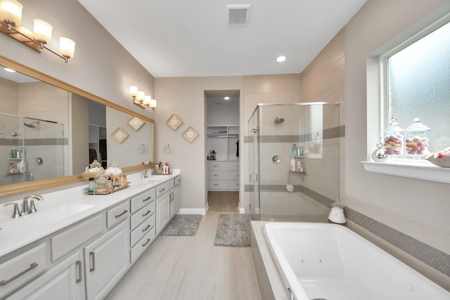 bathroom with double vanity, visible vents, a stall shower, a tub with jets, and a sink