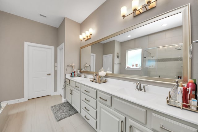 bathroom with a sink, a shower stall, double vanity, and visible vents
