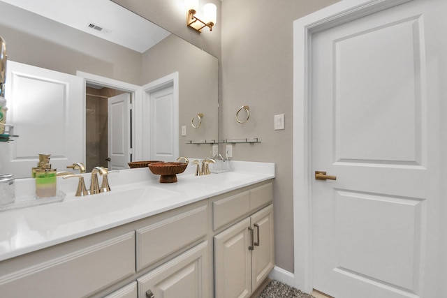 bathroom with double vanity, visible vents, and a sink