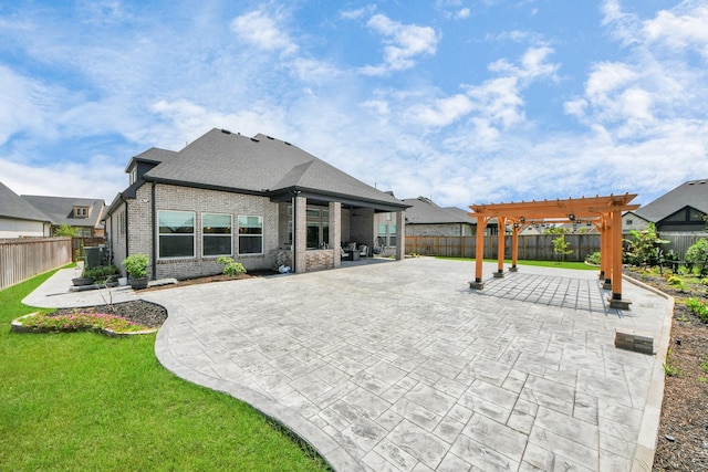 rear view of house with brick siding, a fenced backyard, a patio area, and a pergola