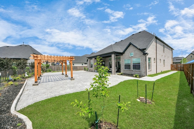 back of house featuring a lawn, a patio area, brick siding, a fenced backyard, and a pergola