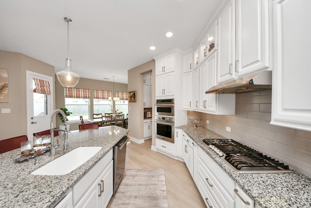 kitchen featuring a sink, appliances with stainless steel finishes, white cabinets, and under cabinet range hood