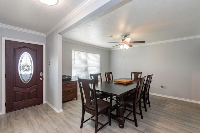 dining space with baseboards, ornamental molding, ceiling fan, and light wood finished floors