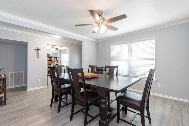 dining space with visible vents, a ceiling fan, and light wood finished floors