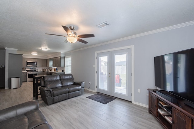 living area featuring visible vents, french doors, crown molding, and baseboards