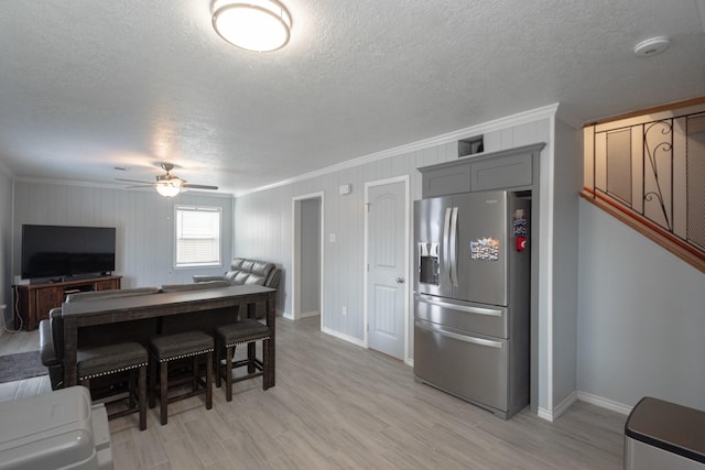 kitchen featuring stainless steel fridge, a textured ceiling, crown molding, and ceiling fan