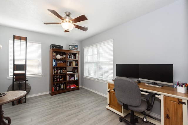 office area featuring ceiling fan, light wood finished floors, and baseboards