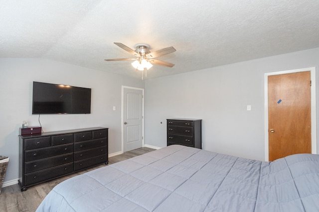 bedroom with ceiling fan, wood finished floors, and baseboards