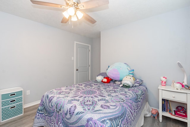 bedroom with wood finished floors, a ceiling fan, and baseboards