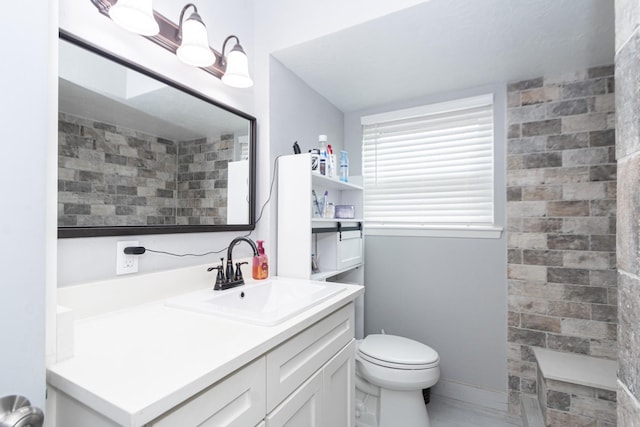 bathroom with vanity, toilet, and tiled shower