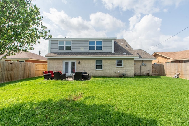 rear view of property featuring a fenced backyard, brick siding, roof with shingles, french doors, and a lawn