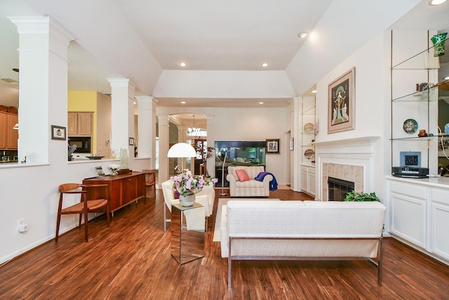 living area with decorative columns, recessed lighting, a tiled fireplace, and wood finished floors