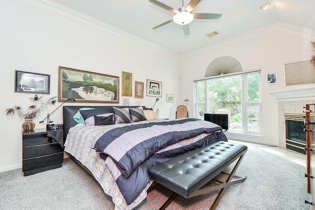 carpeted bedroom featuring ornamental molding, a fireplace, baseboards, visible vents, and a ceiling fan