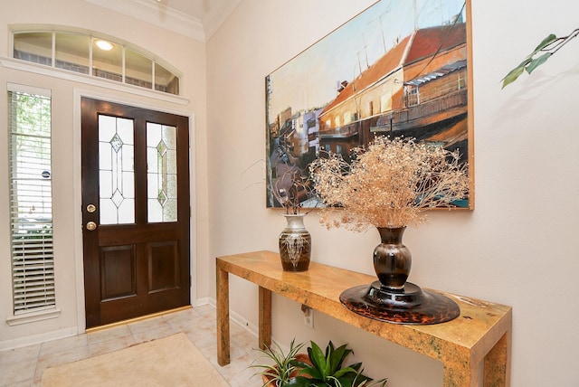foyer with baseboards and crown molding