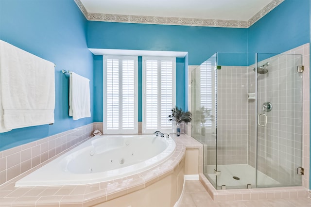 full bathroom featuring a jetted tub, a shower stall, and a wealth of natural light