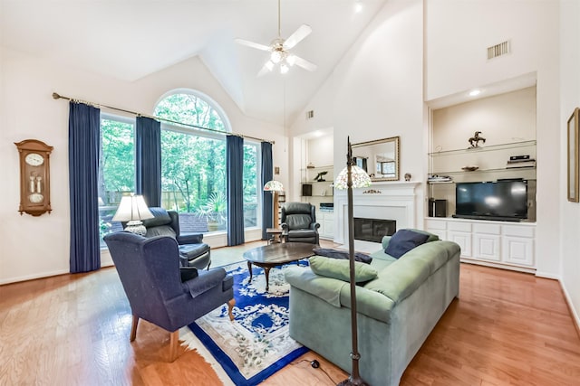 living area featuring baseboards, ceiling fan, light wood-style flooring, and visible vents