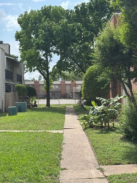 view of home's community featuring a lawn and fence