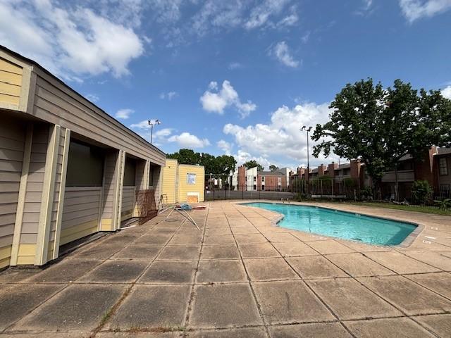 community pool featuring fence and a patio area