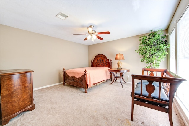 bedroom with baseboards, visible vents, a ceiling fan, and light carpet