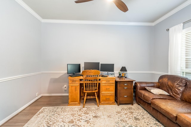 office featuring light wood-style floors, a ceiling fan, baseboards, and crown molding
