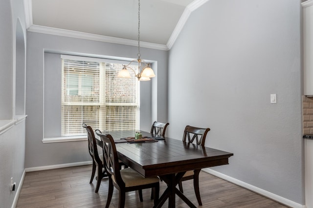 dining space with a healthy amount of sunlight, ornamental molding, wood finished floors, and a notable chandelier