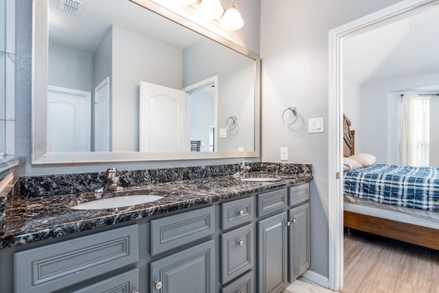 bathroom featuring double vanity, visible vents, a sink, and ensuite bathroom
