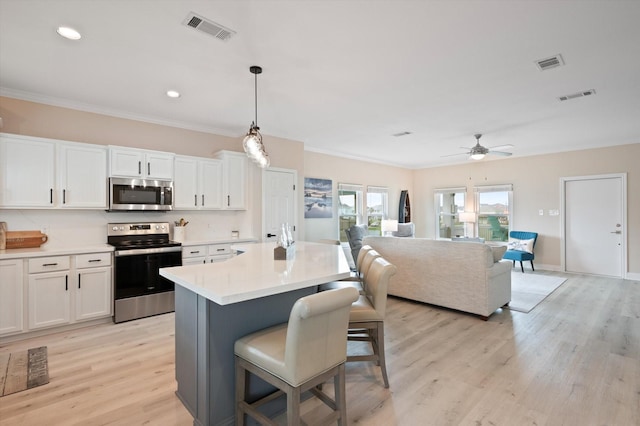 978 Sue Dr, Crystal Beach, TX 77650 - kitchen with visible vents, light wood-style flooring, and stainless steel appliances