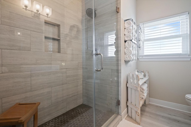 978 Sue Dr, Crystal Beach, TX 77650 - full bathroom with toilet, a stall shower, wood finished floors, and baseboards