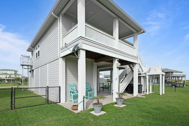 978 Sue Dr, Crystal Beach, TX 77650 - rear view of house with fence, a gate, a lawn, and a patio area