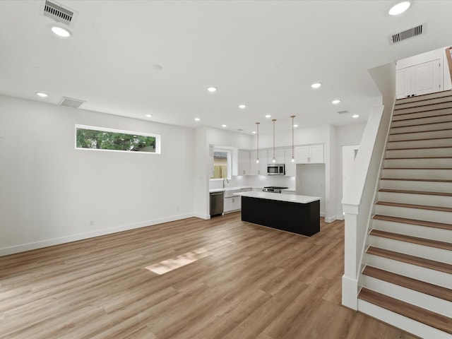 interior space with appliances with stainless steel finishes, visible vents, light countertops, and white cabinets