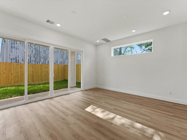 unfurnished room with recessed lighting, visible vents, and wood finished floors