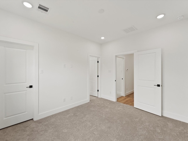 unfurnished bedroom with baseboards, visible vents, carpet, and recessed lighting