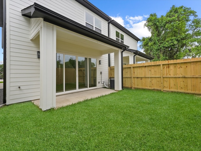 back of property with a yard, a patio area, and fence