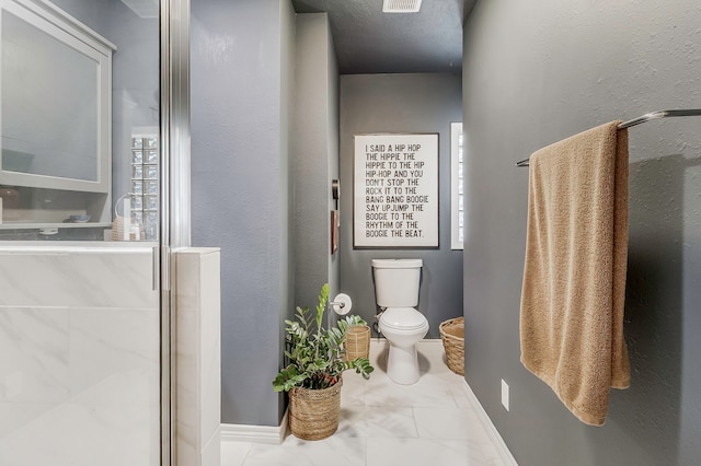 full bath featuring toilet, a shower stall, marble finish floor, and baseboards