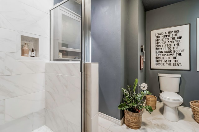 full bathroom with toilet, a shower stall, and baseboards