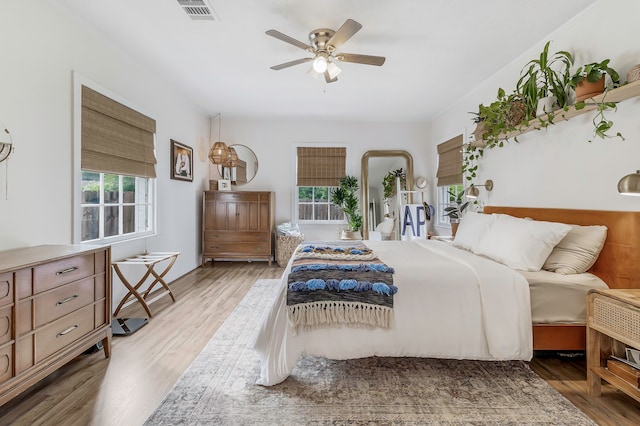 bedroom with visible vents, wood finished floors, and a ceiling fan