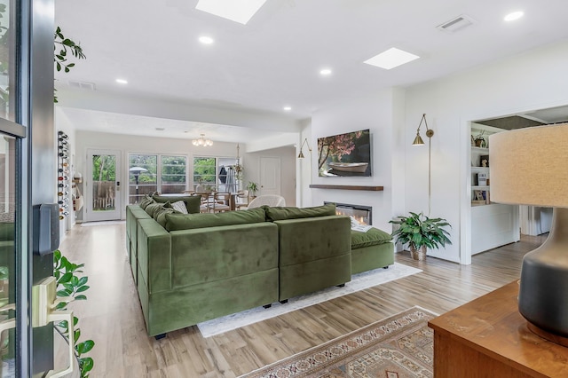 living area with recessed lighting, a skylight, visible vents, and wood finished floors