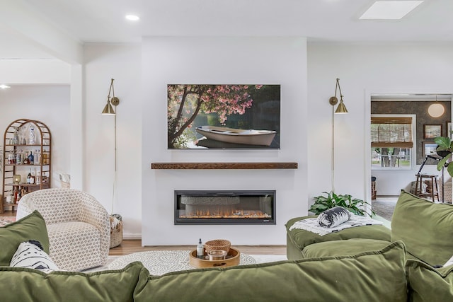 living room with wood finished floors and a glass covered fireplace