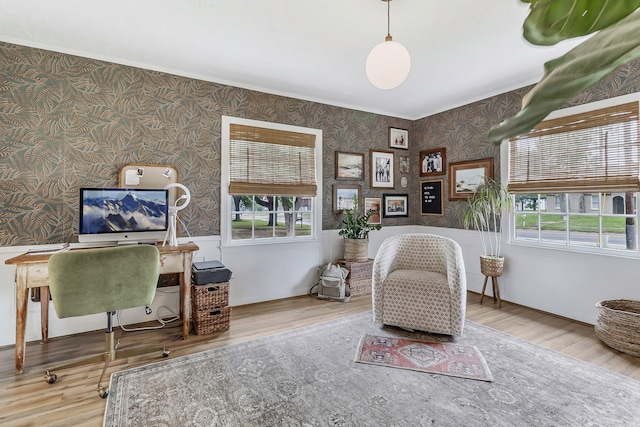 sitting room featuring a wealth of natural light, wood finished floors, and wallpapered walls