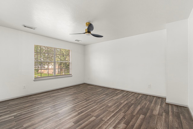empty room with baseboards, visible vents, wood finished floors, and a ceiling fan