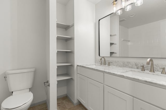 full bathroom with double vanity, toilet, baseboards, and a sink