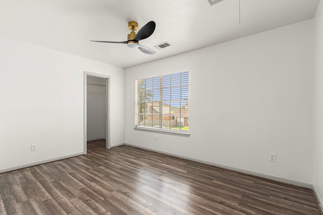 unfurnished bedroom with attic access, visible vents, wood finished floors, and baseboards