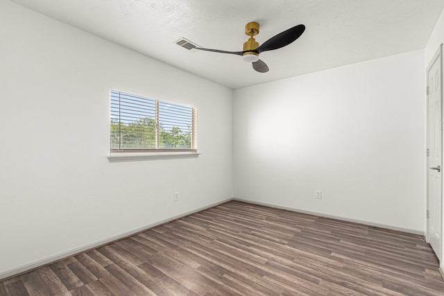 spare room featuring wood finished floors, a ceiling fan, visible vents, and baseboards