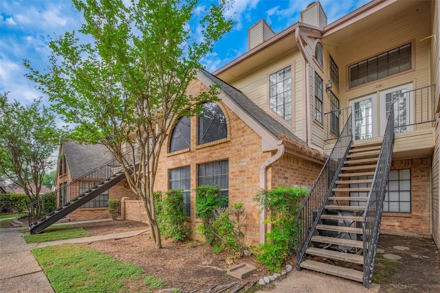 16800 Sugar Pines Dr Unit D28, Houston, TX 77090 - view of side of home with brick siding, stairs, and a chimney