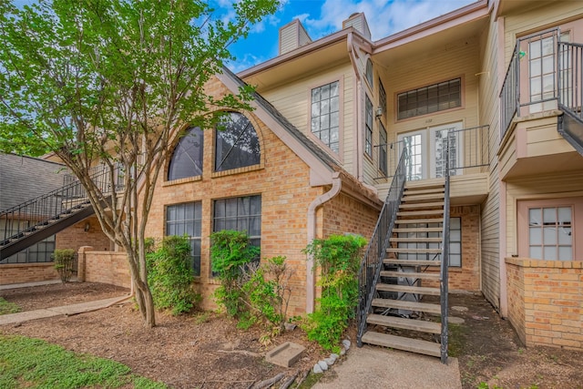 16800 Sugar Pines Dr Unit D28, Houston, TX 77090 - view of property exterior with stairway, a chimney, french doors, and brick siding